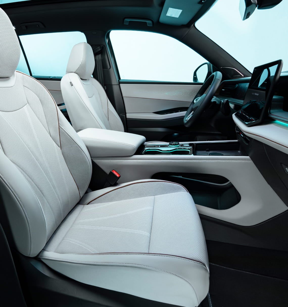 Volkswagen Atlas interior with white front seats, a large center touchscreen, and ambient lighting.